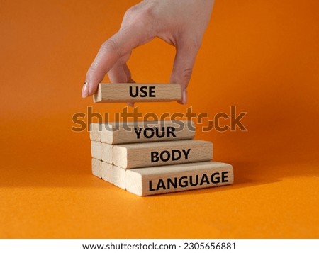 Use your Body Language symbol. Concept words Use your Body Language on wooden blocks. Businessman hand. Beautiful orange background. Business and Use your Body Language concept. Copy space Royalty-Free Stock Photo #2305656881