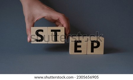 Step symbol. Concept word Step on wooden cubes. Businessman hand. Beautiful grey background. Business and Step concept. Copy space.