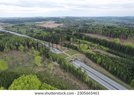 Aerial panorama view of ecoduct or wildlife crossing - vegetation covered bridge over a motorway that allows wildlife to safely cross over,wildlife crossing over busy highway,animal overpass Royalty-Free Stock Photo #2305665461