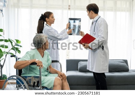 Young Medical Team Meeting With Senior patient In examination room in Hospital, Young Doctor looking knee x-ray film, Female surgeon checking patient's knee condition after surgery