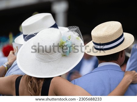 Elegant hats and fancy attire at the horse races  Royalty-Free Stock Photo #2305688233