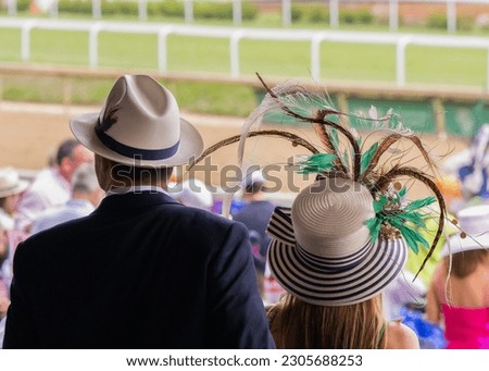 Elegant hats and fancy attire at the horse races  Royalty-Free Stock Photo #2305688253
