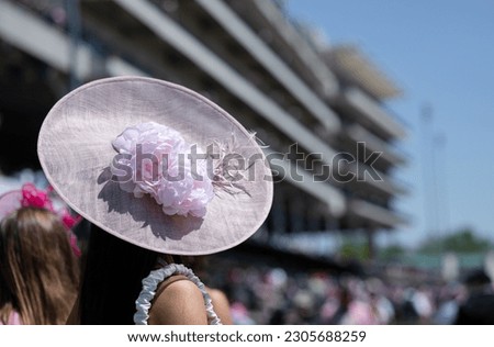 Elegant hats and fancy attire at the horse races  Royalty-Free Stock Photo #2305688259