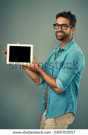 Happy man, tablet and mockup screen for advertising or marketing against a grey studio background. Portrait of male person smiling and showing technology display or copy space for advertisement