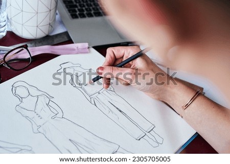 Woman, hands and fashion designer drawing on paper for planning, idea or sketch on office desk. Hand of creative female person, artist or graphic design sketching clothing ideas for startup on table
