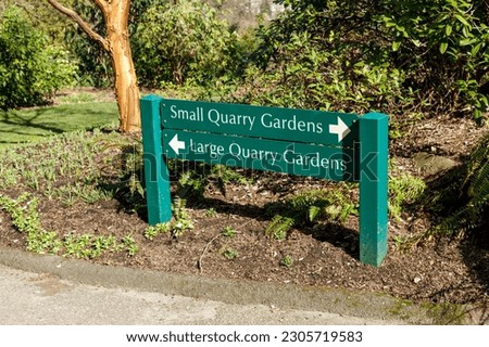 The photo captures the view of directional signs inside Queen Elizabeth Park in Vancouver