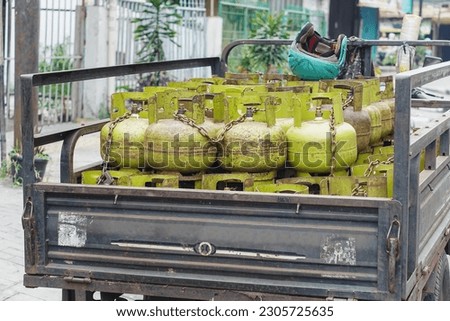 Piles of gas cylinders filled with 3 kilograms on a motorbike cart Royalty-Free Stock Photo #2305725635