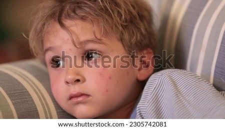 Little boy child watching TV at night. Face of kid staring at screen in the evening