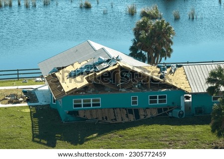 Hurricane Ian destroyed house roof in Florida residential area. Natural disaster and its consequences Royalty-Free Stock Photo #2305772459
