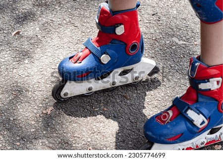 
A child rides on roller skates. Legs in skates and with knee pads. Fall protection. Protection against injuries.