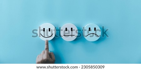 Woman hand touching happy face smile face icon on round blue object. Customer experience and service with satisfaction concept. positive thinking, mental health assessment, world mental health day.