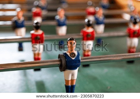 Table football, commonly called fuzboll or foosball (as in the German Fußball "football") and sometimes table soccer, is a table-top game that is loosely based on association football. Royalty-Free Stock Photo #2305870223