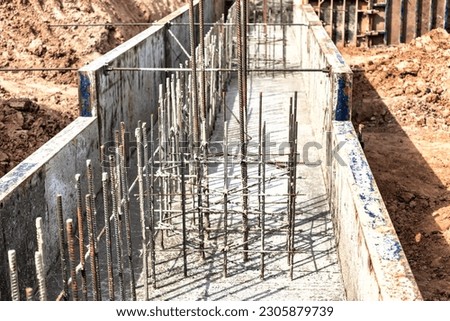 Monolithic reinforced concrete foundations for the construction of a large building. Rostverk at the construction site. Construction pit with foundation. Close-up Royalty-Free Stock Photo #2305879739