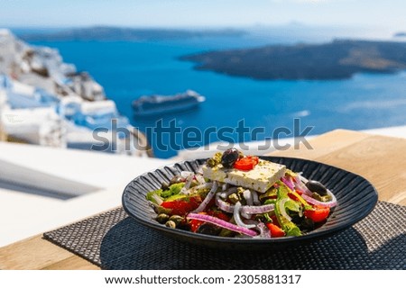 Greek salad with beautiful sea view in Santorini island, Greece. National greek cuisine concept. Travel and vacation Royalty-Free Stock Photo #2305881317