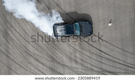 Aerial top view race car drifting on speed track, Professional driver drifting car on race track with smoke, Black tire tracks skid on asphalt road, Wheel tire tracks background. Royalty-Free Stock Photo #2305889419