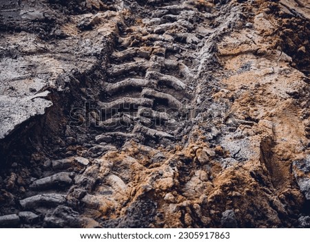 Excavator tire tracks footprint on construction road site Royalty-Free Stock Photo #2305917863