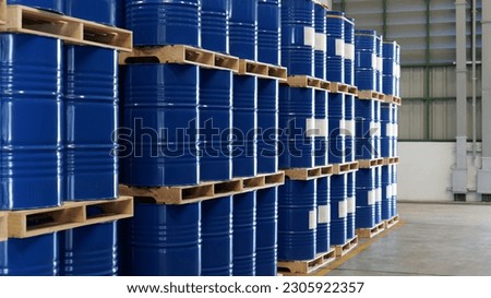 A blue barrel In the warehouse, 200-liter chemical barrels are arranged on wooden pallets and waiting for delivery. Transportation technology, petroleum industry, and chemical industry concepts