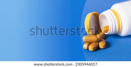 Brown pills on a blue background. Close-up. Tablets capsules, medical and dietary supplements. Copy space