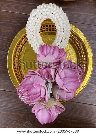 Pink lotus garland on silver tray