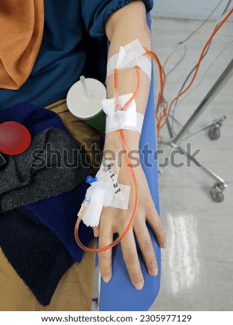 Pictures of a hand being administered cancer related medicine through iv drip.