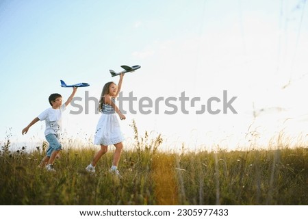 children play toy airplane. concept of happy childhood. children dream of flying and becoming a pilot Royalty-Free Stock Photo #2305977433