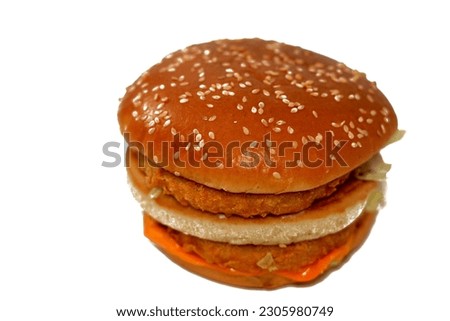 A delicious combination of breaded chicken patties, crisp lettuce, melting cheese, onions, pickles and sauce framed between a toasted sesame seed bun. double chicken burger sandwich, selective focus