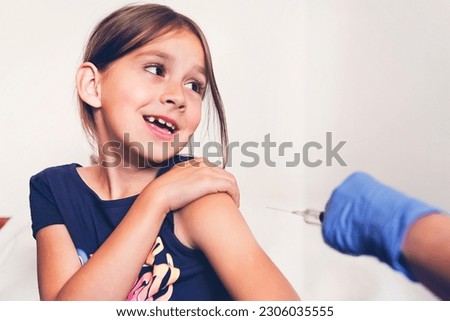 A little girl screams in fear of being shot in the shoulder. Vaccination against dangerous viral diseases. Prevention and protection from viruses. Injection of antibodies. Medical concept. Royalty-Free Stock Photo #2306035555