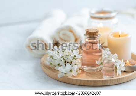 Natural fresh perfume with the scent of apple tree blooming flower on wooden bamboo tray. Aromatherapy, wellness, luxury perfumery concept. Organic ingredients for toilet water and essential oils Royalty-Free Stock Photo #2306042607