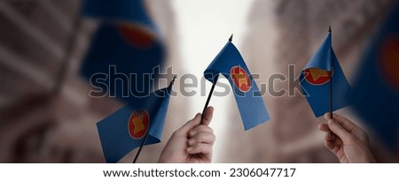 A group of people holding small flags of the ASEAN in their hands. Royalty-Free Stock Photo #2306047717