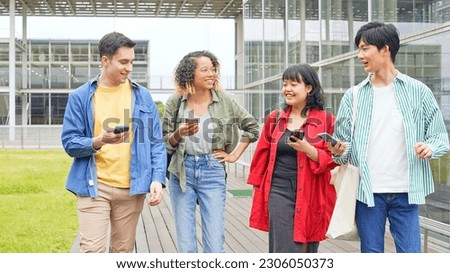 Multinational youth group walking with smart phone in college campus. College students. Royalty-Free Stock Photo #2306050373