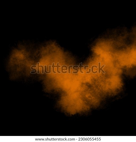 Orange color powder explosion isolated on black background. Royalty high-quality free stock photo image Freeze motion orange powder exploding. Colorful dust explode. Paint Holi, dust particles splash