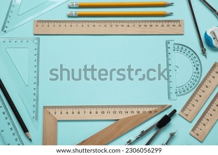 Flat lay composition with different rulers and protractor on turquoise background. Space for text