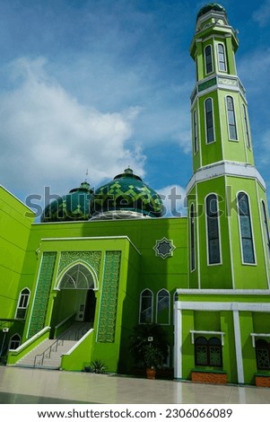 green grand mosque, located in Paser District, Tanah Grogot, Indonesia. The non-english text in the picture is Masjid Nurul Falah, the name of the building or in english : The Winning Light Mosque