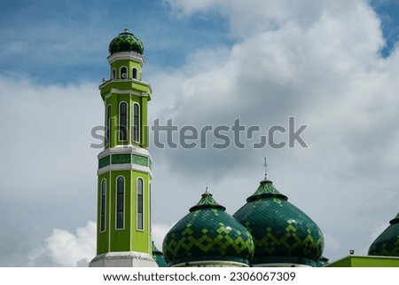 green grand mosque, located in Paser District, Tanah Grogot, Indonesia. The non-english text in the picture means : let's win and let's pray