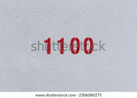 Red Number 1100 on the white wall. Spray paint.
