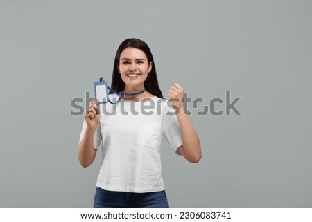 Emotional woman holding vip pass badge on grey background. Space for text