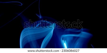 Blue and red light painting photography, long exposure ripples and waves pattern against a black background. Light trails long exposure highway. Blue and gold light painting photography, long exposure