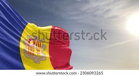 Andorra national flag cloth fabric waving on beautiful sky grey Background.