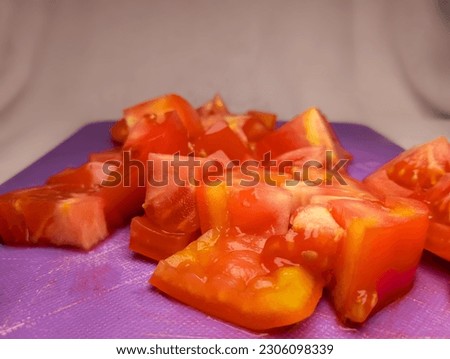 Close up of some sliced tomatoes on a purple cutting board