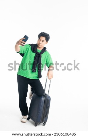Full length of smile young man traveler tourist man doing selfie shot on mobile phone with luggage isolated on White background. Passengers traveling on weekends. Air flight journey concept
