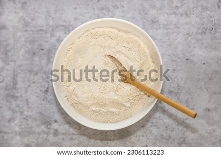 Vital wheat gluten flour in a white bowl.