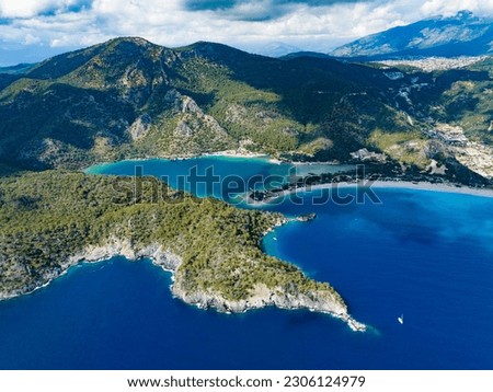 A broad view of Ölüdeniz Bay in Fethiye, Muğla, as seen from a drone. The lush mountains framing the bay enhance the scene's captivating beauty Royalty-Free Stock Photo #2306124979