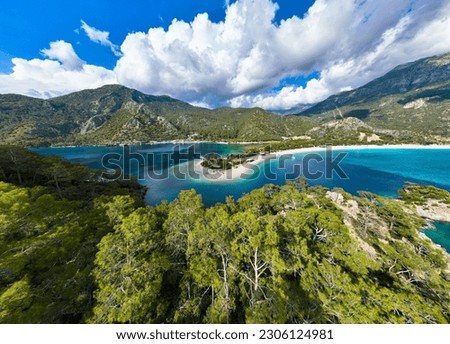 An ultrawide drone image of the serene Ölüdeniz Beach, Fethiye. The scene, beautifully lit by the afternoon light, paints a picture of tranquility. Royalty-Free Stock Photo #2306124981