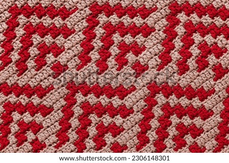 Crochet red beige overlay mosaic pattern. Knitted abstract background.