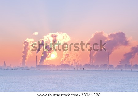 nice winter landscape with industrial smokers with pale sunset