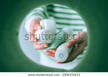 Unrecognizable woman separating trash and sorting plastic waste in garbage bin at home. Cosmetics products for recycling. HDPE. View from the bin. Sustainability concept. space for text Royalty-Free Stock Photo #2306154215