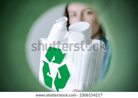 Unrecognizable woman holding container full of cosmetics products for recycling. HDPE. Plastic garbage. Save the planet. Sustainability concept. 