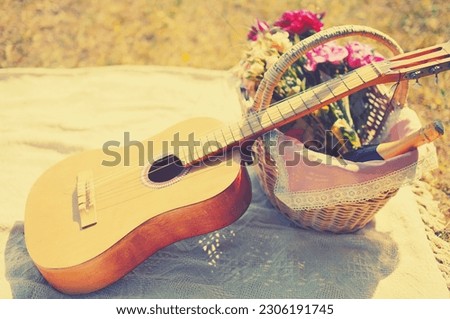 Romantic set, acoustic guitar, basket with wine, bouquet flowers on plaid. Romance, love, date, Valentines day concept