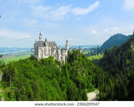 Fairytale castle. 
Picturesque landscape. Romantic castle of the Bavarian king. Amazing background. 
Alps in Bavaria. A view of the castle in the mountains. Screensaver for phone.