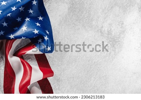Ruffled USA flag on bright white background with copyspace for text. US American flag background for Memorial Day, Veteran's Day, 4th of July, or other patriotic event.